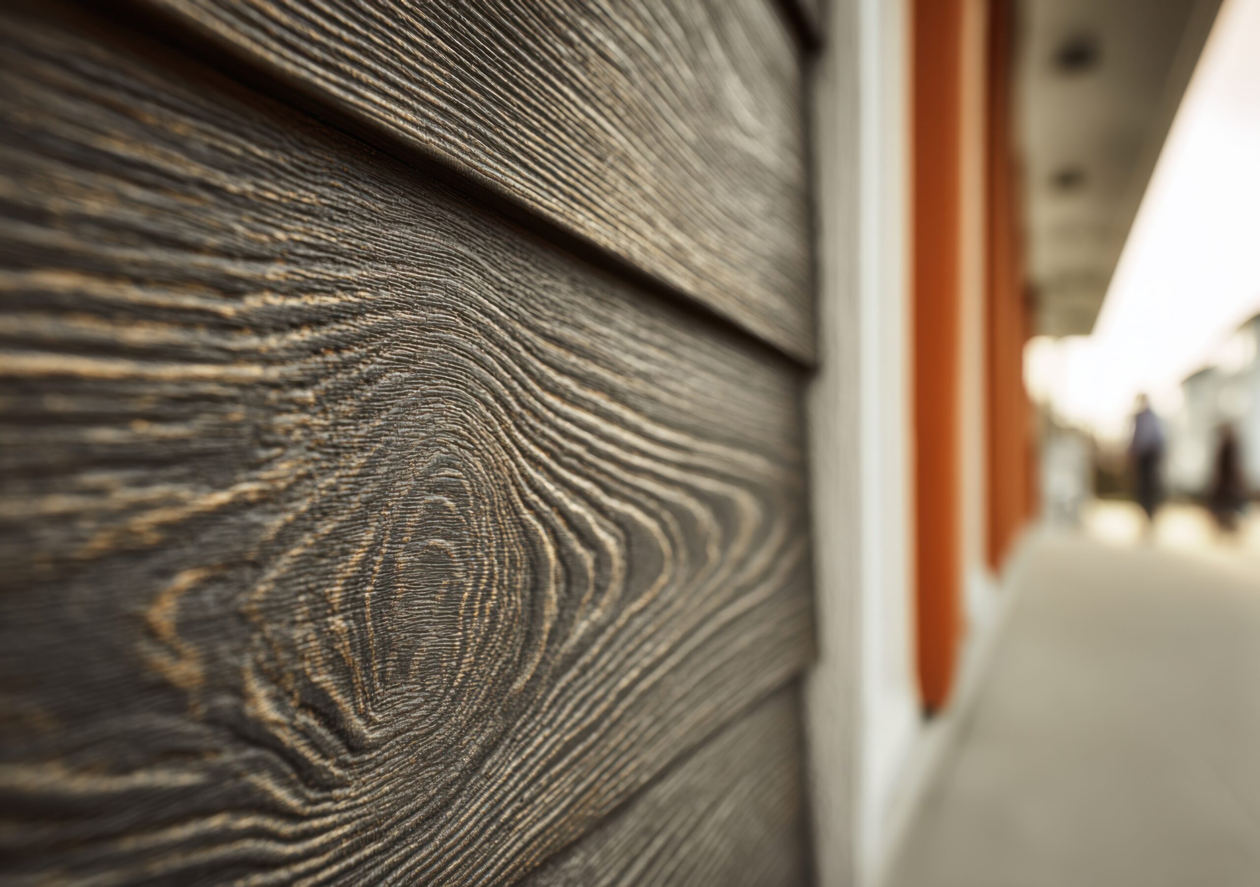 "Custom faux wood grain finish applied to fiber cement wall panels, showcasing detailed scenic artistry and realistic texture in a professionally installed themed environment.